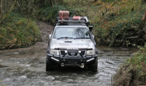 A nissan patrol green laning through a river in worcestershire.