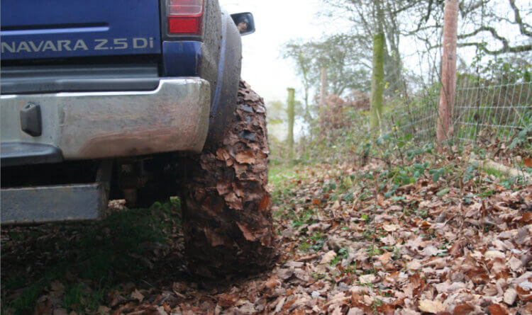 a 4x4 zoomed in tyre shot covered in mud and leaf fr the A Beginner's Guide to Green Laning