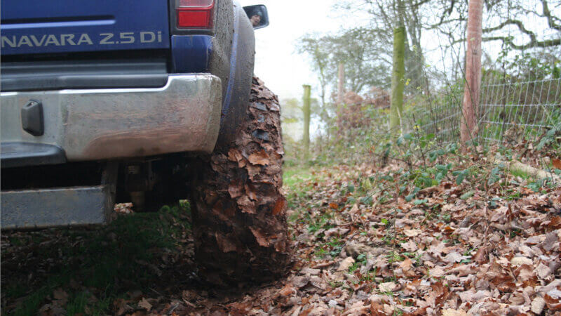 a 4x4 zoomed in tyre shot covered in mud and leaf fr the A Beginner's Guide to Green Laning