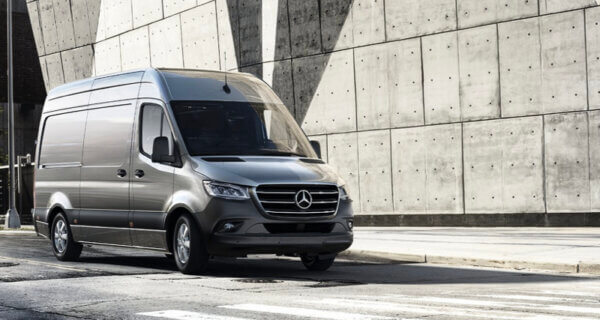 Mercedes-Benz Sprinter van parked outside a modern concrete building