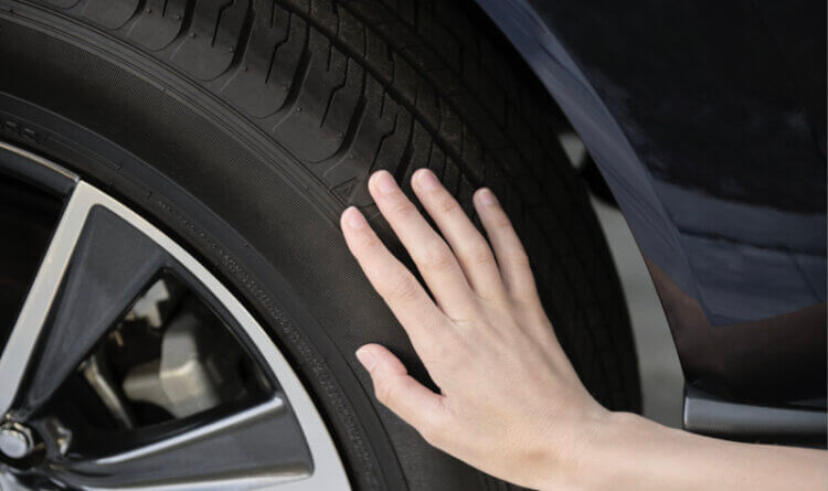 A driver touching a Tyre to check Pressure Safety