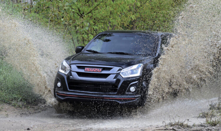 An Isuzu D MAX driving through thick mud on General Grabber AT3