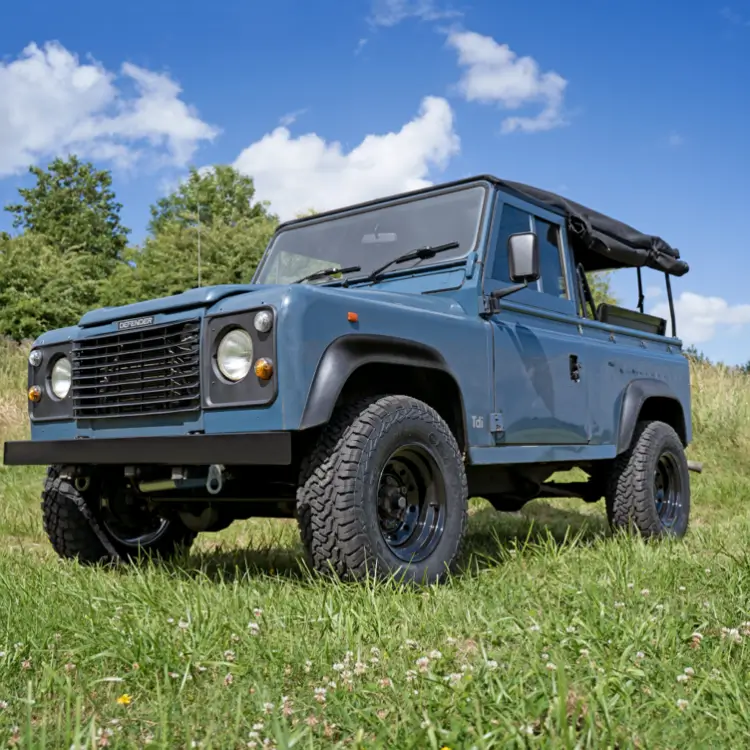 A classic blue land rover defender sat on steel wheels by tuff torque