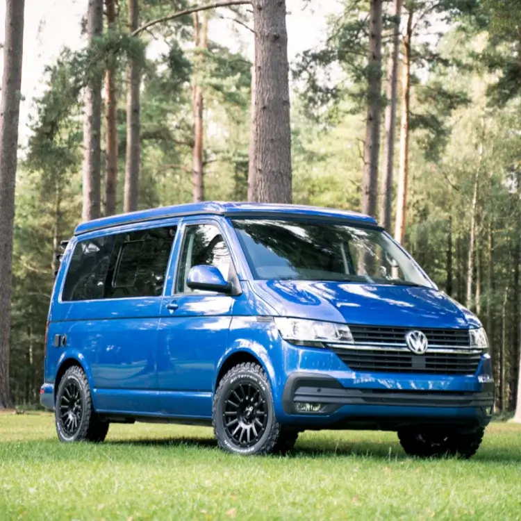 a vw camper van sat on alloy wheels and tyres in a forest