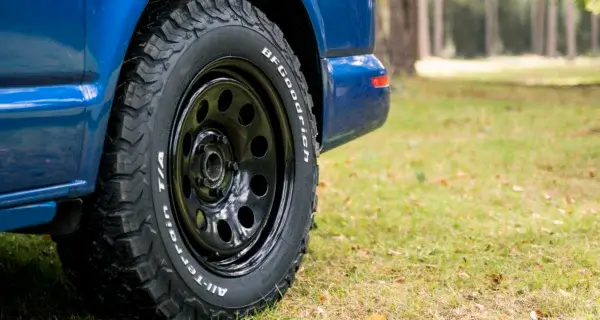 a vw transporter sat on steel wheels on a campsite