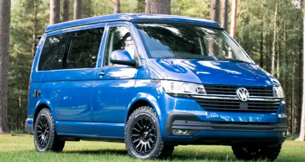a vw transporter sat on alloy wheels and bfgoodrich wheel and tyre package on a campsite