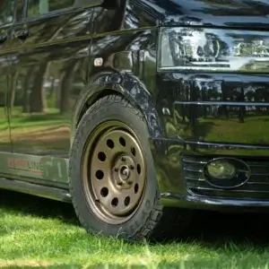 Front three-quarter view of Volkswagen Transporter fitted with Tuff Torque D Mod satin bronze steel wheels and Comforser all-terrain tyres