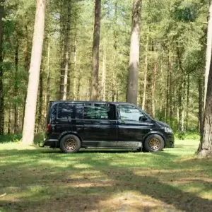 Side profile of Volkswagen Transporter T5 with Tuff Torque D Mod satin bronze steel wheels in woodland