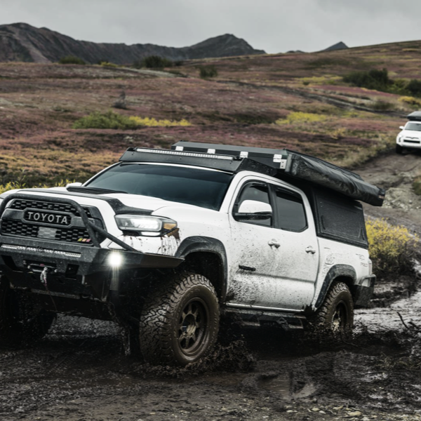 Toyota 4x4 driving through muddy off-road terrain on BFGoodrich KO3 all-terrain tyres
