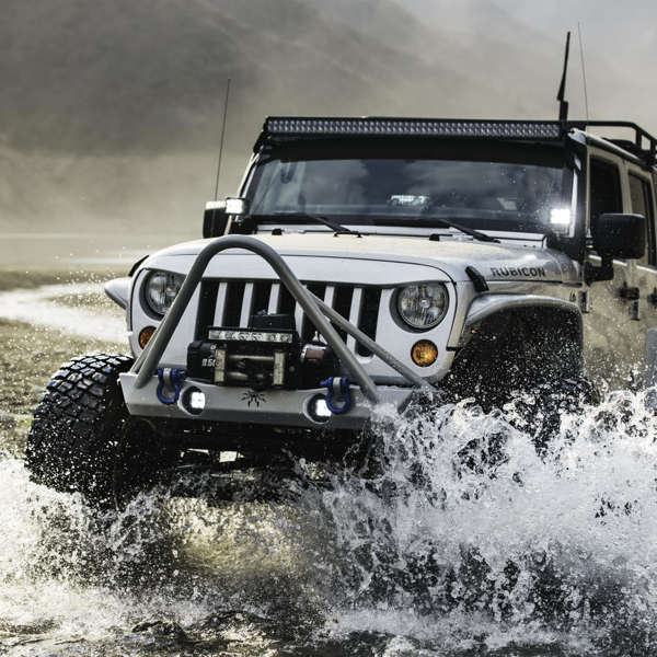 Jeep Wrangler driving through deep water on rugged off-road tyres