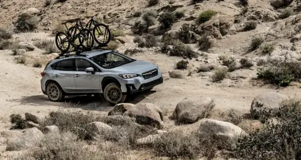 Off-road pickup with camping awning and rooftop gear at sunset