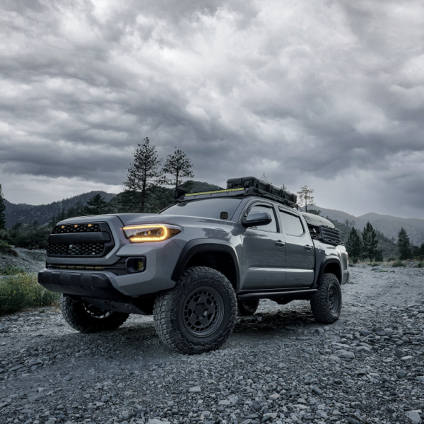 Grey off-road pickup fitted with all-terrain tyres on a rocky mountain trail