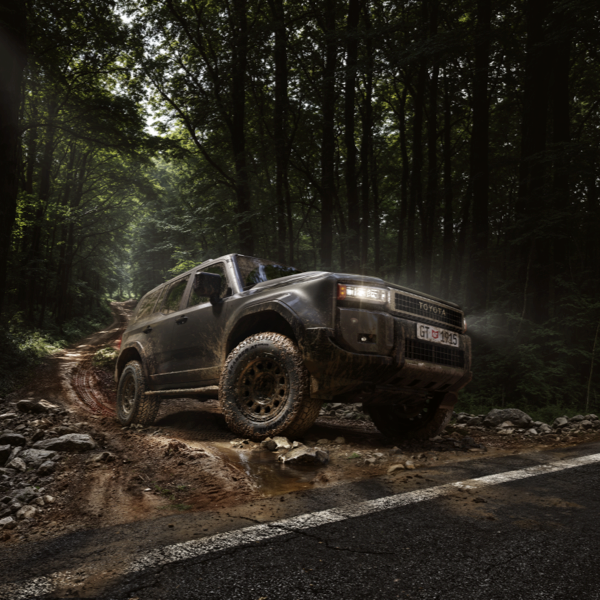 Toyota Land Cruiser fitted with General Grabber AT3 Plus tyres driving from an off-road forest trail onto the road